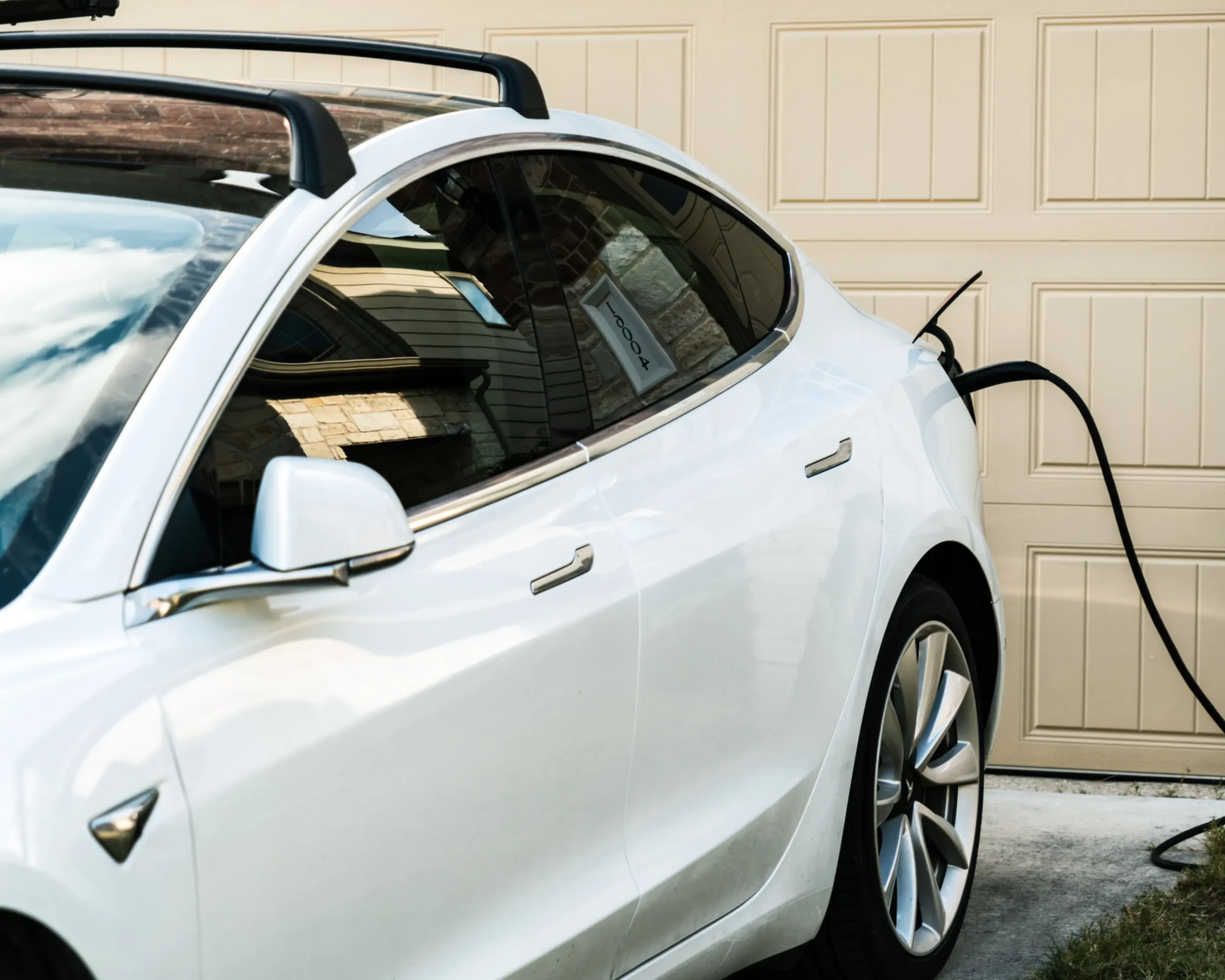 Tesla electric vehicle charging outside a residential garage | Primary Electric | Wasilla, AK